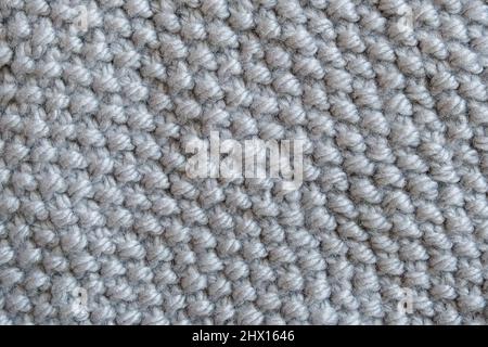 Pezzo di tessuto a maglia grigio, maglia Pearl Pattern. Sfondo o trama. Foto Stock