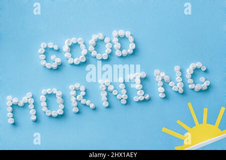 Testo 'Buongiorno' da marshmallows e figura di sorgere del sole su sfondo blu. Concetto Foto Stock