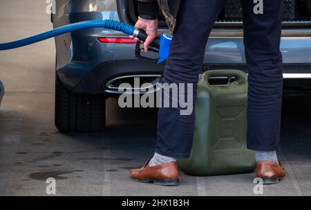 Wasserbillig, Lussemburgo. 08th Mar 2022. Un uomo riempie un barattolo di carburante a Wasserbillig, Lussemburgo, vicino al confine tedesco. Nel Granducato, i prezzi del carburante fissati dal governo sono aumentati, ma sono ancora ben al di sotto di quelli della Germania. Credit: Harald Tittel/dpa/Alamy Live News Foto Stock