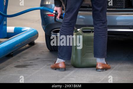 Wasserbillig, Lussemburgo. 08th Mar 2022. Un uomo riempie un barattolo di carburante a Wasserbillig, Lussemburgo, vicino al confine tedesco. Nel Granducato, i prezzi del carburante fissati dal governo sono aumentati, ma sono ancora ben al di sotto di quelli della Germania. Credit: Harald Tittel/dpa/Alamy Live News Foto Stock