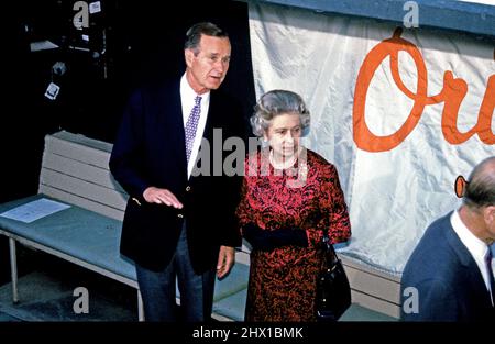 Il presidente degli Stati Uniti George H.W. Bush, a sinistra, parla con la Regina Elisabetta II di Gran Bretagna, a destra, mentre visitano il Memorial Stadium di Baltimora, Maryland, per vedere gli Oakland Athletics giocare i Baltimore Orioles il 15 maggio 1991. L'atletica ha vinto il gioco 6 - 3.Credit: Arnie Sachs / CNP /MediaPunch Foto Stock