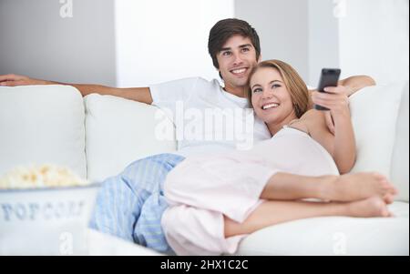 Pronto per la serata cinematografica. Una giovane coppia che guarda un film a casa. Foto Stock