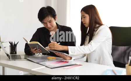 Interior designer femminile che ha un incontro con il cliente maschile per riassumere la bozza finale. Foto Stock