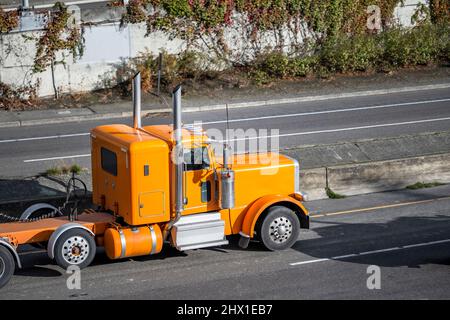 Trattore semi-camion classico con carro di perforazione industriale arancione con accessori cromati e vano di appoggio per il conducente di autocarri per il trasporto di carichi in pista per semirimorchio Foto Stock