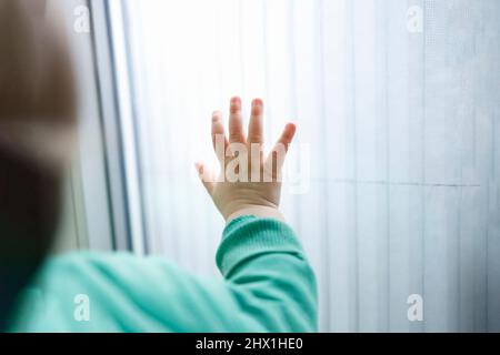 Una mano di un bambino piccolo su una superficie bianca, concetto di aiuto umanitario Foto Stock