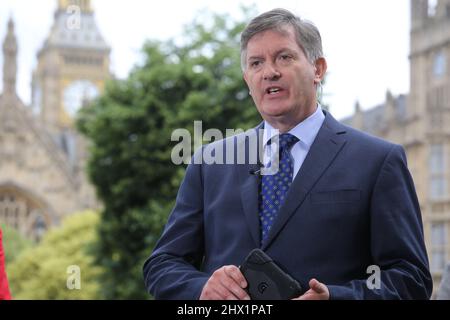 Una fotografia della BBC anchorman Simon McCoy parlando con il Big Ben in background dopo il risultato dell'UE Foto Stock