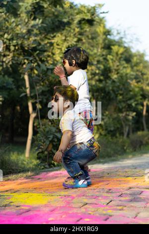 Felice Asian Indian Kids Boy e ragazza godendo il Festival dei colori con polvere di colore Holi chiamato Gulal o Rang Foto Stock