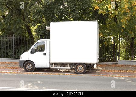 Un vecchio furgone da carico parcheggiato su una strada della città. Vecchia auto retrò e arrugginita. Auto sulla strada della città in autunno Foto Stock