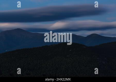 Silhouette del Presidential Range dal Molo Pan di zucchero di mezzo a Betlemme, New Hampshire in una serata estiva nuvolosa al crepuscolo. Lavaggio del supporto Foto Stock