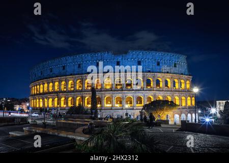 Vista notturna del Colosseo illuminata dai colori della bandiera Ucraina, sullo sfondo del cielo blu di una fredda notte invernale. Foto Stock