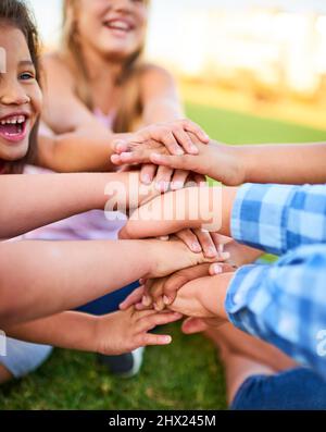 Il suo freddo essere gentile. Scatto ritagliato di un gruppo di bambini che impilano le mani l'una sull'altra. Foto Stock