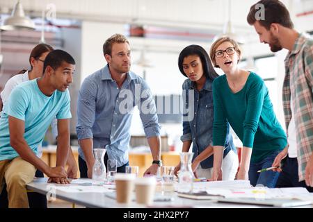 Il lavoro di squadra fa funzionare il sogno. Foto di un gruppo di giovani designer che hanno un incontro di brainstorming. Foto Stock