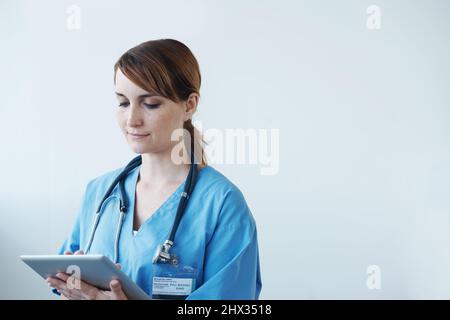 Diagnosi dei pazienti mediante strumenti digitali. Una dottoressa che lavora su un tablet digitale. Foto Stock