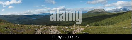 Vista panoramica sulla valle con foresta profonda, lago Tjaktjajaure, montagne, collina e rocce. Paesaggio selvaggio del sentiero escursionistico di Kungsleden nella nazionale di Sarek Foto Stock