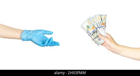 La mano femminile del paziente dà un medico in blu guanti medici soldi cento dollari fatture. Corrompere al medico. Concetto di medicina a pagamento Foto Stock