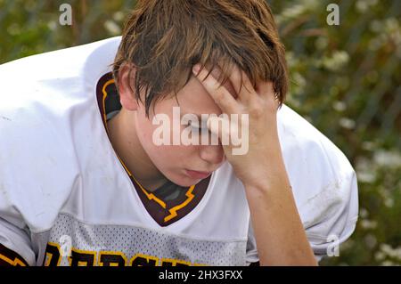 gioco di calcio e mani e così di 11 e 12 giocatori di anni che stanno perdendo il gioco e sentirsi male Foto Stock