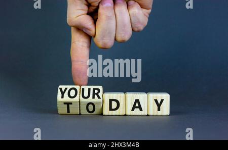 Oggi è il tuo simbolo del giorno. L'uomo d'affari trasforma i cubi di legno e cambia le parole di concetto oggi al vostro giorno. Bellissimo sfondo grigio, spazio di copia. Affari, Foto Stock