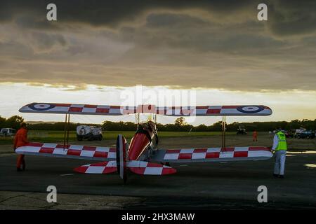 De Havilland D.H. 82A Tiger Moth II biplanare T6953 in attesa di partire dopo uno spettacolo aereo a Dunsfold con pesanti nuvole di tempesta nera in testa. Minaccioso Foto Stock