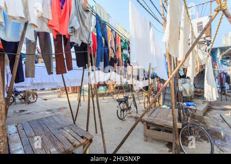 I vestiti puliti e lavati appesi fuori per asciugare, asciugandosi al sole all'aperto in Mahalaxmi Dhobi Ghat, una grande lavanderia all'aperto a Mumbai, India Foto Stock