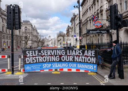 Londra, Inghilterra. 9th marzo 2022. Un banner che dice "i Liars serventi stanno distruggendo la nostra nazione”. Gli attivisti anti-conservatori al di fuori del Parlamento per protestare contro il governo conservatore e il primo Ministro britannico, Boris Johnsons, coinvolgimento nella Brexit. Credit: SMP News / Alamy Live News Foto Stock