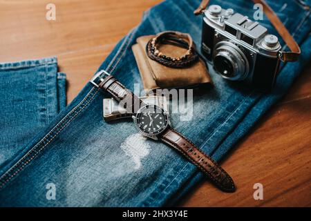 Accessori uomo su scrivania in legno. Primo piano all'orologio