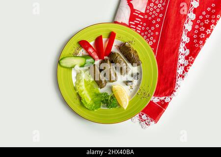 Yaprak Sarma con insalata in un piatto isolato su colorato tavolo panno vista dall'alto su sfondo grigio Foto Stock