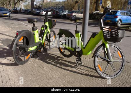 'S-Hertogenbosch, Paesi Bassi - 12 febbraio 2022: Due bici elettriche verdi sulla strada nel centro Foto Stock