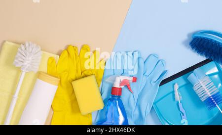 Disposizione degli utensili per la pulizia su sfondo blu pastello e beige. Casa di posa piatta lavora utensili spazio copia Foto Stock