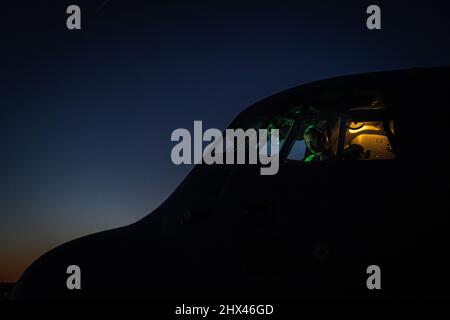 RAF Lakenheath, Regno Unito. 26th Feb 2022. Un pilota assegnato allo Squadron Airlift 37th effettua controlli prima del decollo presso la base aerea Lakenheath, Regno Unito, 27 febbraio 2022. Il movimento di carico e personale dell'Ala Airlift 86th C-130J mira a sostenere le missioni alleate della NATO nell'Europa orientale. Credit: U.S. Air Force/ZUMA Press Wire Service/ZUMAPRESS.com/Alamy Live News Foto Stock