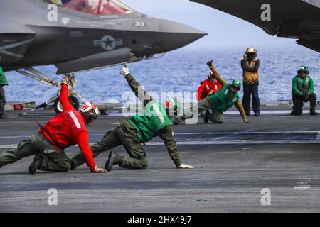 Mar delle Filippine. 23rd Feb 2022. Marines segnala un F-35C Lightning II, assegnato ai 'Cavalieri neri' di Marine Fighter Attack Squadron (VMFA) 314, per il lancio dal ponte di volo della portaerei di classe Nimitz USS Abraham Lincoln (CVN 72). Abraham Lincoln Strike Group è in fase di implementazione pianificata nell'area delle operazioni della flotta USA 7th per migliorare l'interoperabilità attraverso alleanze e partnership, fungendo da forza di risposta pronta a supportare una regione indopacifica libera e aperta. Credit: U.S. Navy/ZUMA Press Wire Service/ZUMAPRESS.com/Alamy Live News Foto Stock