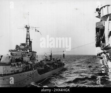 Una valutazione navale che viene trasferita dal cacciatorpediniere Cheviot al portaerei Theseus durante gli esercizi combinati della flotta domestica e mediterranea che si stanno attualmente svolgendo nel Mediterraneo. Marzo 24, 1952. (Foto della fotografia ufficiale britannica). Foto Stock