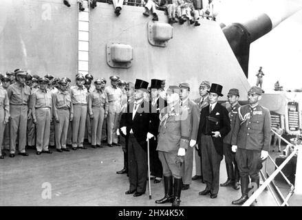 Ufficiali giapponesi arrivano alla nave da guerra degli Stati Uniti per la cerimonia di consegna -- La delegazione militare e diplomatica giapponese, guidata dal ministro degli Esteri Mamoru Shigemitsu (con canna) e dal generale Yoshijiro Umezu (fronte, a destra), capo dello Stato maggiore imperiale, arriva a bordo della corazzata statunitense Missouri per assistere alle cerimonie di consegna formale, come osservano gli ufficiali militari alleati. I documenti della capitolazione giapponese sono stati firmati il 1 settembre 1945, a bordo della corazzata da 45.000 tonnellate a Tokyo-Bay, a sud della capitale giapponese. Giugno 9, 1945. Foto Stock