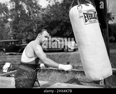 Sharkey pugna il sacco Jack Sharkey mostrato punzonare il sacco di sabbia pesante al suo campo di allenamento qui oggi, come ha iniziato i suoi allenamenti preparatori al suo pesante lotta con Joe Louis. Febbraio 17, 1953. (Foto di stampa associata). Foto Stock