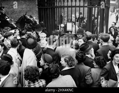 Leggi l'avviso di nascita - le folle premono in avanti per leggere l'avviso, fissato sulle porte di ferro della Clarence House di Londra (centro) annunciando la nascita di una figlia alla principessa Elisabetta e al duca di Edimburgo alle ore 1950 GMT, agosto 15. Il nuovo bambino, terzo in linea di successione, è il primo bambino reale nato a Clarence House, residenza londinese della principessa Elisabetta, l'altro figlio della principessa Elisabetta, il principe Carlo, ha 21 mesi. Agosto 31, 1950. (Foto di stampa associata). Foto Stock