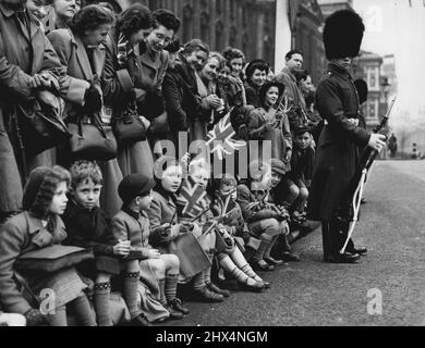 Il re sta arrivando - i bambini di Londra ottengono a ondeggiare le loro bandiere mentre attendono la processione reale per andare oltre per l'odierna apertura di Stato del Parlamento. Il Re e la Regina, nel pullman dello Stato Irlandese, hanno guidato attraverso le strade fino a Westminster per la cerimonia. Marzo 6, 1950. (Foto di Paul Popper Ltd.). Foto Stock