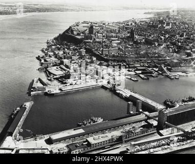 Quebec City: Situato su un terreno alto che si affaccia sul fiume St. Lawrence, Quebec è una delle città più antiche e storiche del Canada. La vista aerea sopra è stata presa guardando attraverso le eccellenti strutture portuali, verso le torri e guglie della città che circondano la cittadella storica con le pianure di Abraham e Wolfe Cove sullo sfondo. Giugno 18, 1946. (Foto di Photographic Survey Ltd.). Foto Stock