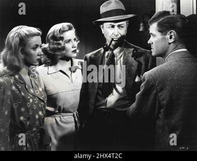 Tough Talk -- Paul Kelly (a destra) si rompe in una conversazione per rivelare alcuni fatti interessanti nel dramma radio RKO, 'Crossfire'. I tre ascoltatori sono (da sinistra a destra) Gloria Grahame, Jacqueline White e Robert Young. Ottobre 1, 1947. Foto Stock