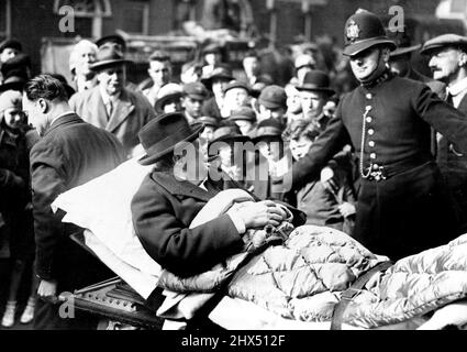 Il Happy Invalid - il sig. Winston Churchill sorridendo e fumando sulla sua barella quando è stato preso da una casa di infermiera del West End al suo appartamento a Westminster. 01 novembre 1932.(Foto di Central News) Foto Stock