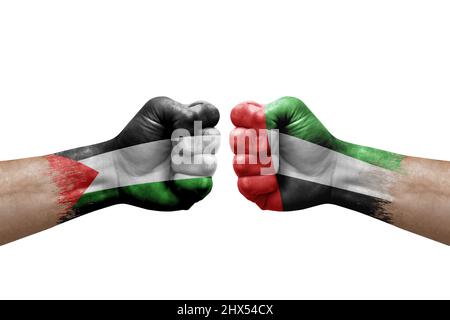 Due mani si pugno l'una all'altra su sfondo bianco. Bandiere di paese dipinte pugni, conflitto concetto di crisi tra palestina ed emirati arabi uniti Foto Stock