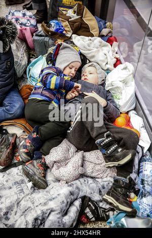 Cracovia, Polonia. 09th Mar 2022. I ragazzi rifugiati ucraini riposano sul pavimento dopo essere arrivati alla stazione ferroviaria principale di Cracovia, in quanto più di milioni di persone sono già fuggiti dall'Ucraina per la Polonia - 9 marzo 2022. Mentre la Federazione russa ha invaso l'Ucraina, il conflitto tra Ucraina e Russia dovrebbe costringere fino a 5 milioni di ucraini a fuggire dal paese. Molti dei rifugiati chiederanno asilo in Polonia. Le fughe sono spesso ospitate da individui e ONG (Foto di Dominika Zarzycka / Sipa USA) credito: Sipa USA / Alamy Live News Foto Stock