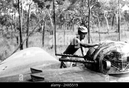 Un membro indonesiano del personale di terra di uno squadrone medio dell'esercito dell'esercito delle Indie dei Paesi Bassi, che pulisce le torrette di pistola di un aereo ad una base australiana. Con le pistole di coda presidiate da un attaccato personale R.A.F. e pilotate da uomini olandesi questi aerei sono abilmente serviti da membri di entrambe le unità, e stanno prendendo una parte attiva nelle incursioni sul territorio occupato nemico. Aprile 17, 1945. (Foto di Netherlands Information Service) Foto Stock