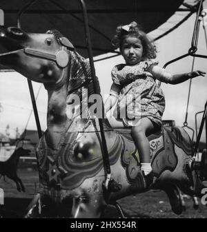 PAM Smithson 2 anni di Marrickville il suo primo giorno dopo una lunga malattia ha visitato il R.S.L. "Happy Land" al McNeilly Park Marrickville. Il fatto che la fiera fosse chiusa per il giorno non importava Pam, era contento di sedersi su un cavallo 'Round about' al sole. Marzo 31, 1949. Foto Stock