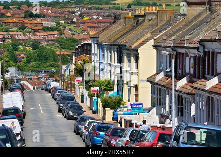 Case a schiera e cartelli di agenti immobiliari (in vendita e venduti) su una tipica strada residenziale suburbana, Kemptown, Brighton, East Sussex, Inghilterra, REGNO UNITO Foto Stock