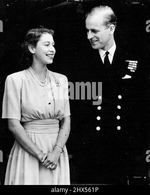 La Royal Engagement Picture sorridendo felicemente, la principessa e la sua fidanzata sono raffigurate oggi a Buckingham Palace. L'anello di fidanzamento della principessa Elisabetta è chiaramente visibile nella foto. S.R.H. principessa Elisabetta e Lieut. Philip Mountbatten, R.N., ex Principe Filippo di Grecia, dove viene annunciato l'impegno di oggi posto, per le loro prime foto di fidanzamento a Buckingham Palace. Per le foto la Principessa indossava il vestito di seta gialla daffodil del diamante del suo anello d'aggancio, affiancato su ogni lato da diamanti baguette, gleamed nella luce morbida. Luglio 10, 1947. Foto Stock