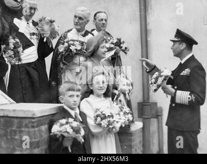 Il Re con Posies, arrangiando un'immagine del giorno di Maundy -- una fotografia informale del Re, portando un posto di fiori, arrangiando un gruppo per una fotografia dopo la cerimonia del giorno di Maundy a noi ***** Abbey oggi Apr 18. Dietro la Regina c'è il Vescovo di Lichfield, che ha condotto il Servizio Maundy. Il Re distribuì i soldi Royal Maundy nell'Abbazia di Westminster oggi 18 aprile. Maggio 05, 1946. (Foto per stampa associata) Foto Stock