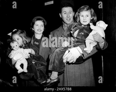 Quayle Family Off on Australasian Tour -- il Sig. E la Sig.ra Anthony Quayle con i loro figli alla partenza da Liverpool Street che la Sig.ra Quayle (Dorothy Hyson) è ***** Jennifer, 2½; il Sig. Quayle tiene Rosanna, 4½.Members di una società di 30 artisti e tecnici dallo Shakespeare Memorial Theatre, Stratford-on-Avon, a sinistra Liverpool Street Station, Londra, al giorno (Martedì) per salire a bordo del liner Rangitikei della New Zealand Shipping Company al Royal Albert Dock, Londra. Sono spenti per un tour di nove mesi in Nuova Zelanda e Australia sotto la guida di Anthony Quayle (co-direttore di Glen Foto Stock