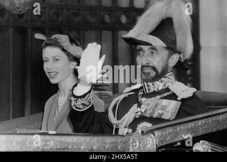 L'Imperatore arriva al Palazzo -- l'Imperatore Haile Selassie ondeggia alla folla mentre guida nel piazzale di Buckingham Palace con la Regina. La Regina, il Duca di Edimburgo e altri membri della famiglia reale si trovavano a Victoria Station, Londra, questo pomeriggio (giovedì) per dare il benvenuto all'imperatore Haile Selassie d'Etiopia al suo arrivo per una visita di Stato di tre giorni. L'imperatore, accompagnato dal figlio, il duca di Harae, viaggiò da Malta nell'incrociatore reale HMS Cambia e fu incontrato a Portsmouth dal duca di Gloucester, che lo accompagnò a Londra. Durante il suo stato visi Foto Stock