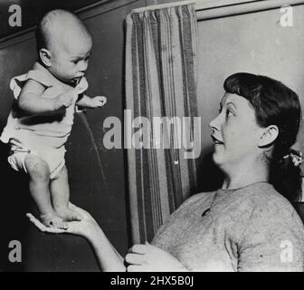 Super-Babe - Seven-Week-Old Susan Elaine Davey di Stockton si erge da solo nel palmo della mano di sua madre, la signora Edward Davey, 22, moglie di un longshoreman e madre di altri tre figli, i più vecchi otto anni. Susan ha iniziato a stare da solo una settimana fa e sta tentando di camminare. Febbraio 25, 1954. (Foto di AP Wirephoto). Foto Stock