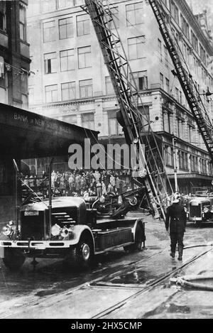 Incendio cittadino. Brigate combattendo il fuoco che ha gutled gli uffici della NSW National Coursing Association all'ultimo piano di Derwent House, Liverpool Street, all'inizio di oggi, causando migliaia di sterline di danni. Luglio 14, 1949. Foto Stock