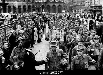 I prigionieri tedeschi e collaboratori belgi si sono arrotondati per la cattura britannica di Anversa -- prigionieri tedeschi che sono stati marchati attraverso le strade di Anversa, con la stazione centrale sullo sfondo. Andando oltre la Bruxelles appena liberata, tre colonne volanti di armature britanniche si sono recate per Anversa. La velocità dell'anticipo ha preso i difensori tedeschi di sorpresa, e a mezzanotte il 4th settembre la cattura del più grande pert del Belgio era stata annunciata. Settembre 1, 1944. Foto Stock